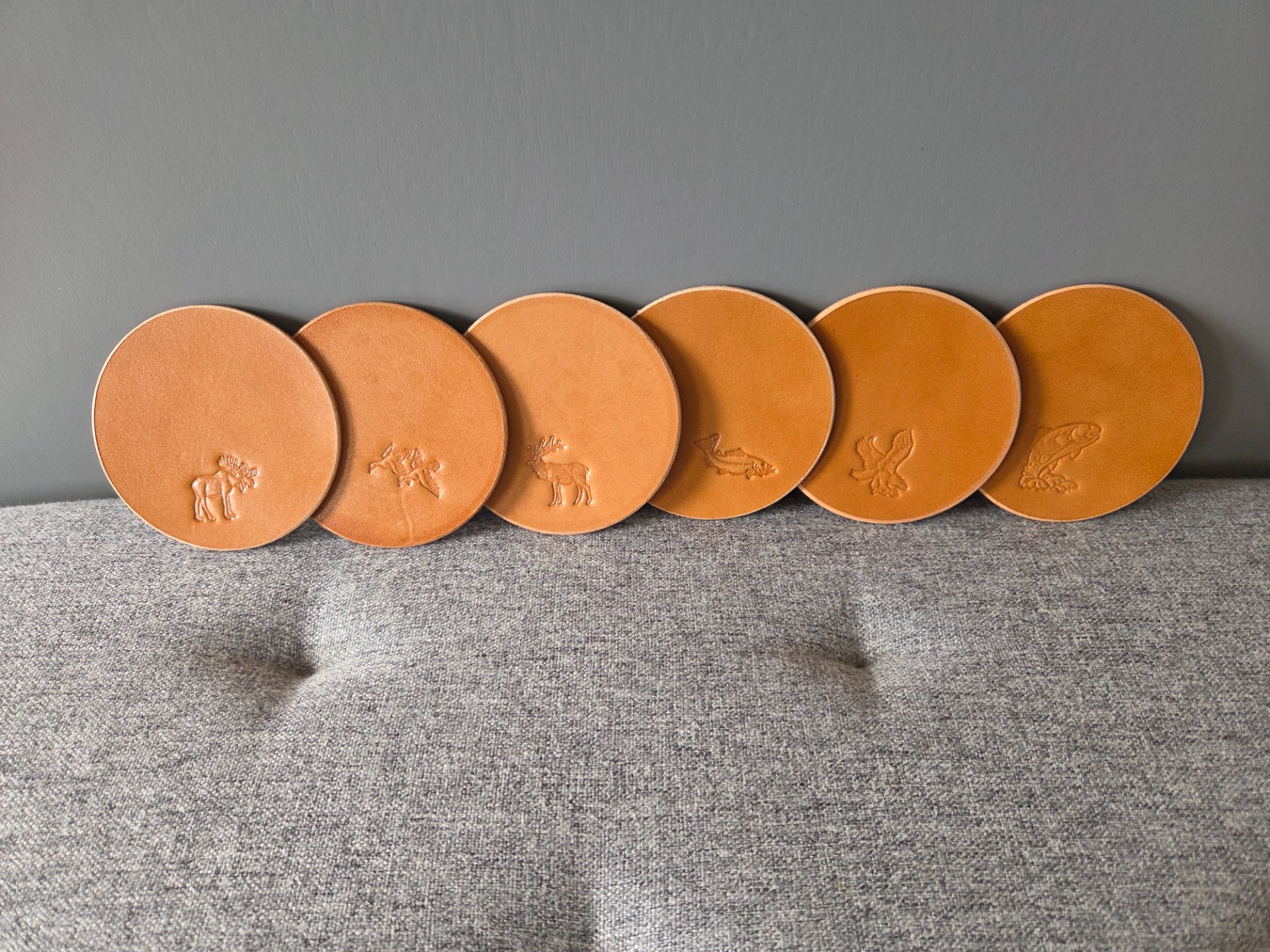Glasunderlägg i läder med djurmotiv.