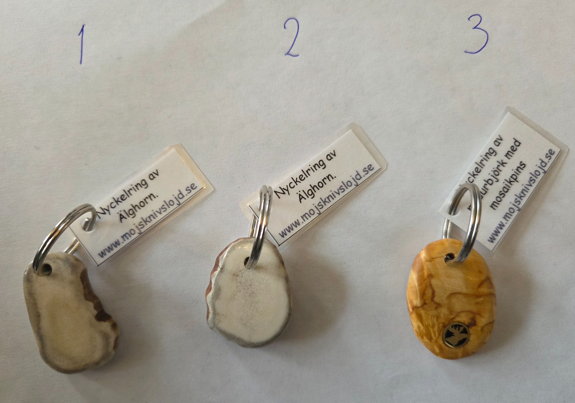 Pris/st: 70 kr. Nyckelringar av älghorn och av masurbjörk med mosaikpins i form av en älg.